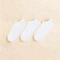 Three white cotton ankle socks arranged neatly on a soft beige background ankle socks 3 pack