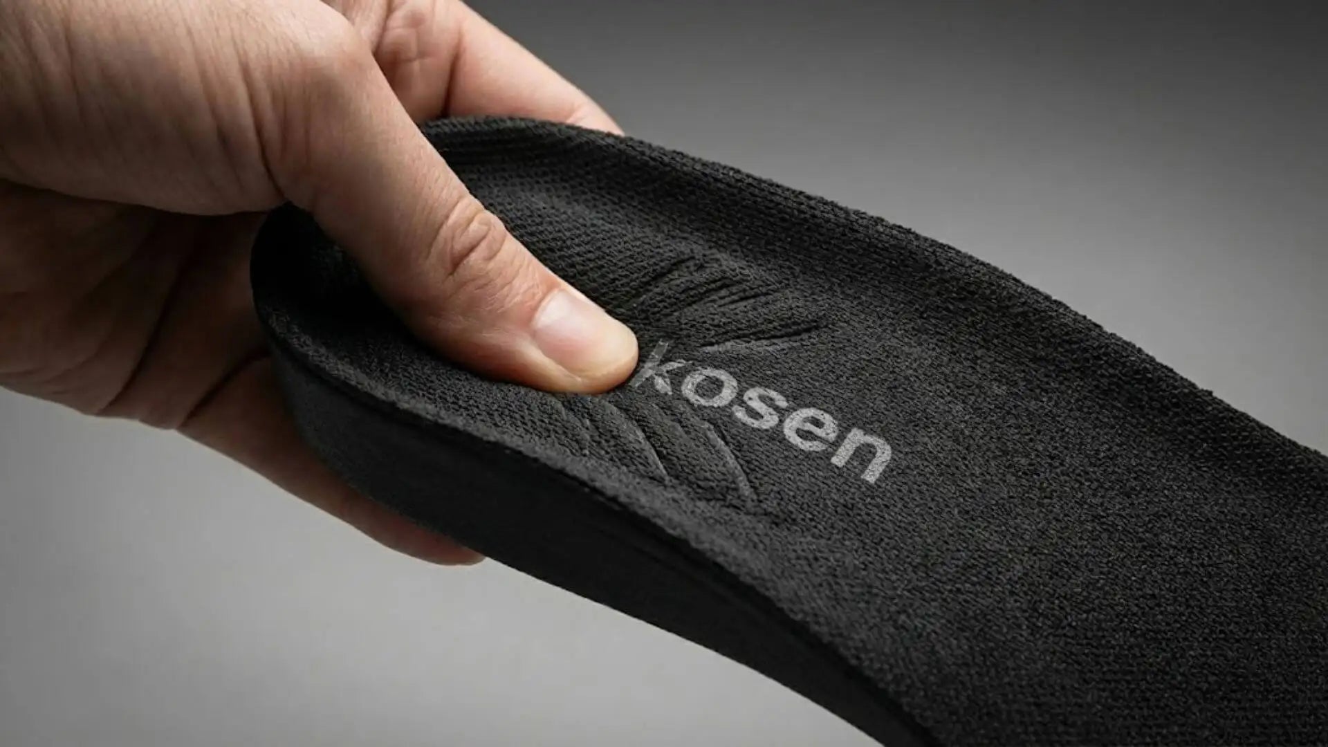 Black kosen insole with textured fabric surface and subtle embossed branding.