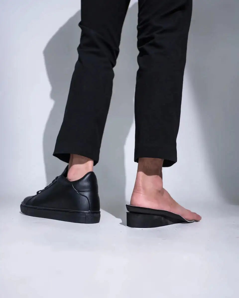 Cutaway view of black Kosen elevator sneakers showing hidden lift technology. In-house manufactured height increasing shoes.