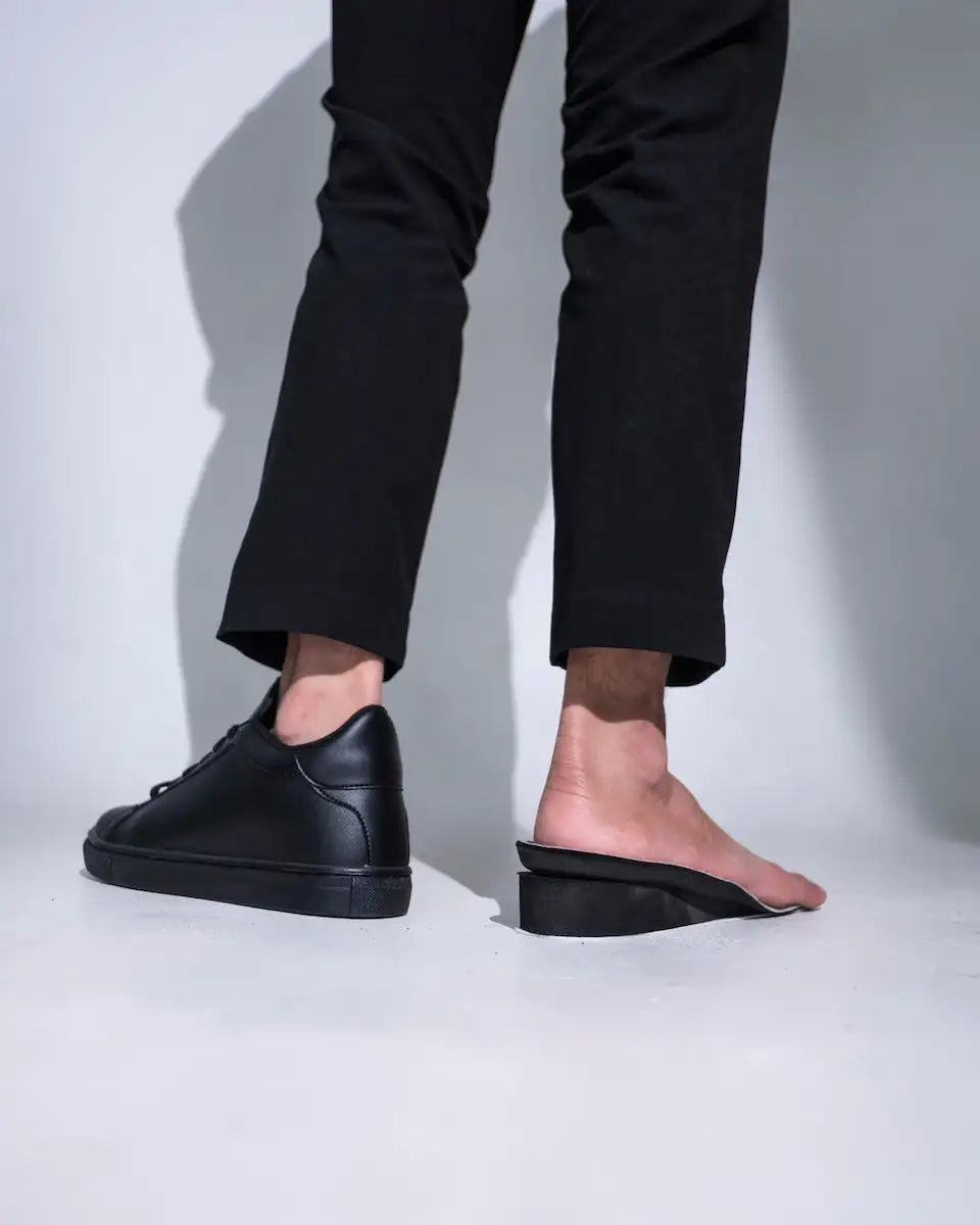Black leather slip-on sneakers with a chunky sole and minimalist design