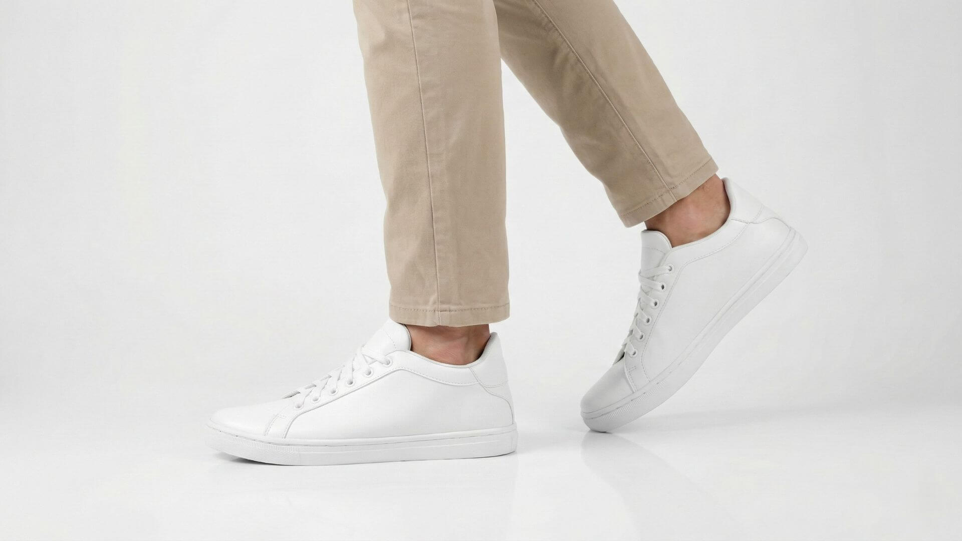 White elevator shoes by Kosen adding extra height with beige trousers for a sleek, confident look