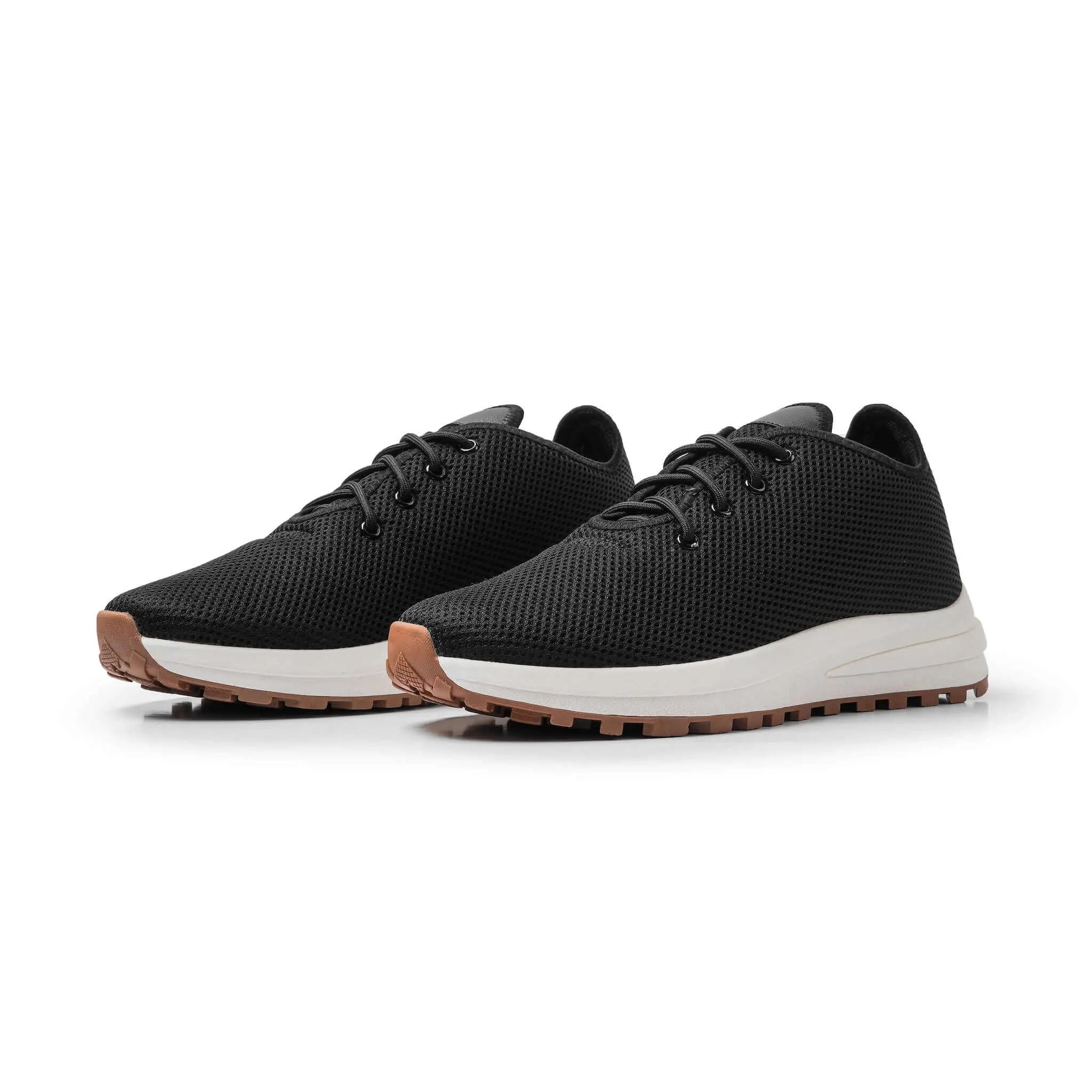 Pair of Venus Black elevator sneakers. Lightweight black knit height increasing shoes with white soles.